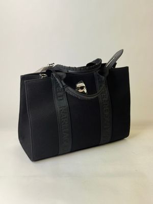 the black handbag is sitting on a white surface with a white background