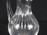 a clear glass pitcher sitting on a black surface