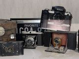 a lot of old cameras sitting on a table