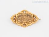 a close up of a coin in a gold brooch