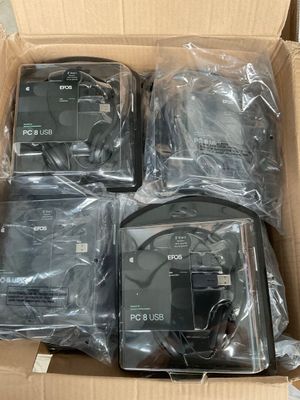 quatre appareils électroniques se trouvent dans une boîte en carton posée sur une table