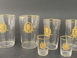 six glasses with gold designs on them sitting on a table