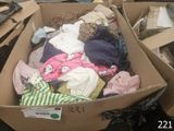 a cardboard box full of clothes on the ground