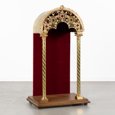 une image représentant une chaire dorée et rouge recouverte de velours rouge