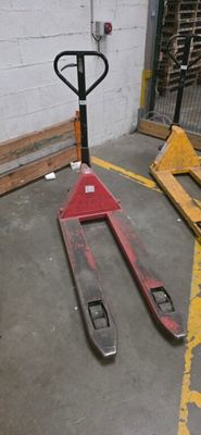 a fork lifter sitting in a warehouse with pallets in the background