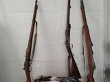 Deux armes sont posées sur une caisse en bois dans une pièce.