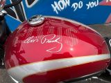 a red motorcycle parked in front of a blue wall