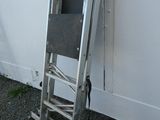 a ladder leaning against a white wall with a chair on it