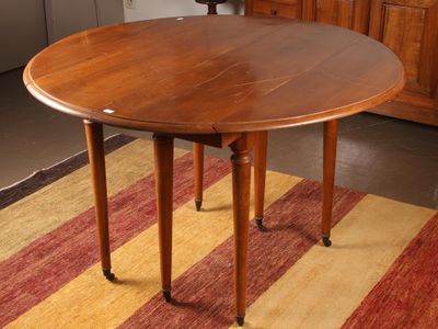 a round table with a wooden top on a striped rug