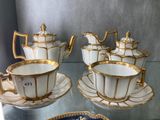 several cups and saucers are sitting on a glass table