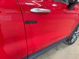 a close up of a red car door with a sticker on it