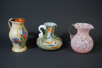 three different colored vases sitting next to each other on a black surface