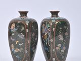 pair of vases sitting on a white surface with a white background