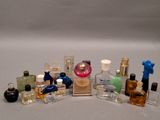 many different bottles of perfume on a white surface