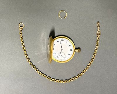 une petite montre de poche en or, attachée à une chaîne