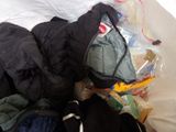 a pile of clothes that is on a bed