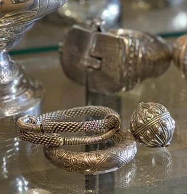 a glass table with silver jewelry on it