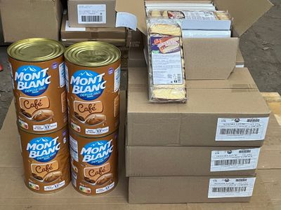 several cans of food are stacked on top of boxes on a pallet