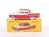 a red and white toy car sitting on top of a yellow box