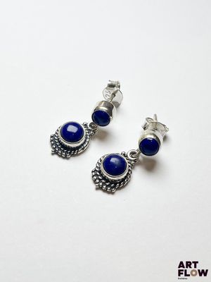 une paire de boucles d'oreilles ornées de pierres bleues sur fond blanc