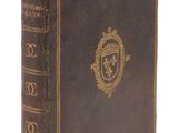un vieux livre avec un emblème en or sur la couverture
