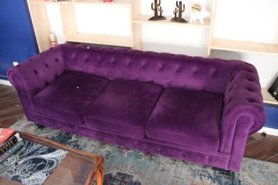 un canapé violet dans un salon aux murs bleus