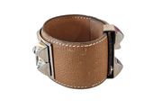 brown leather cuff bracelet with silver studs on a white background