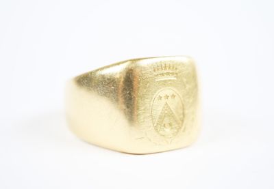 an image of a gold signet ring with a crest on it