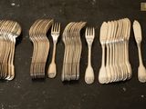 six fourchettes et cuillères sont alignées sur une table