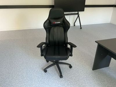 une chaise de bureau noire placée devant un bureau noir