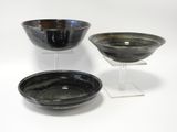 trois bols noirs et blancs posés sur une surface blanche
