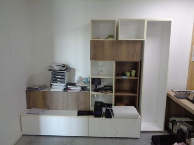 une photo d'une pièce avec un bureau et une bibliothèque