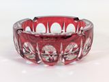 a red glass bowl with a flower design on it