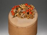 a gold and red brooch on top of a wooden box