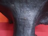 une sculpture noire posée sur une table rouge recouverte d'une nappe rouge