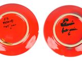 two red plates with black writing on them sitting side by side