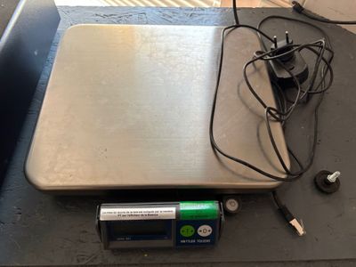 une balance posée sur une table sur laquelle se trouve un chargeur
