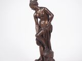 une statue en bronze représentant un homme assis sur un rocher