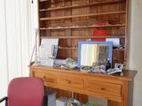 a desk with a chair and a bookcase in the corner