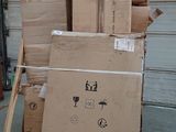 a stack of boxes on a pallet in front of a garage door