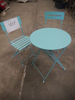 deux chaises et une table posées à même le sol dans un entrepôt