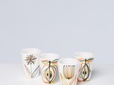 trois bols blancs ornés de motifs colorés, posés sur une table