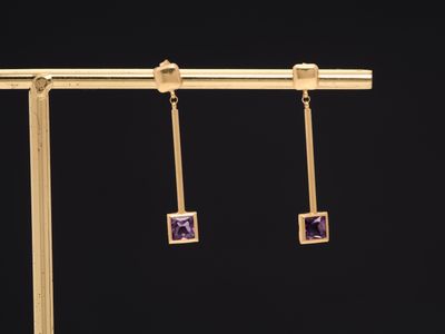 a pair of gold earrings with amethorate and diamonds