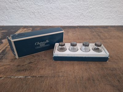 une image représentant une boîte contenant quatre petites bouteilles, posée sur une table en bois