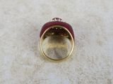 an image of a gold and red ring with a diamond