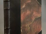 un vieux livre avec une couverture noire et une couverture rouge et noire