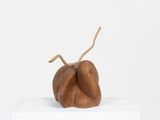 an image of a wooden sculpture of a pear on a white pedestal