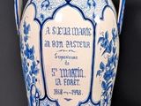 un vase bleu et blanc posé sur une table près d'un mur
