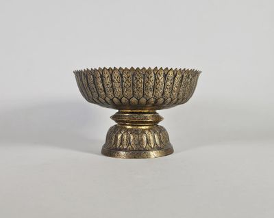 un bol ancien en laiton orné d'un motif décoratif sur le socle