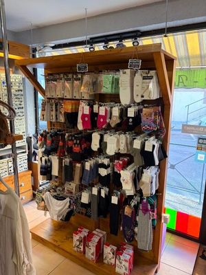 une femme debout dans un magasin, en train de regarder un présentoir de vêtements